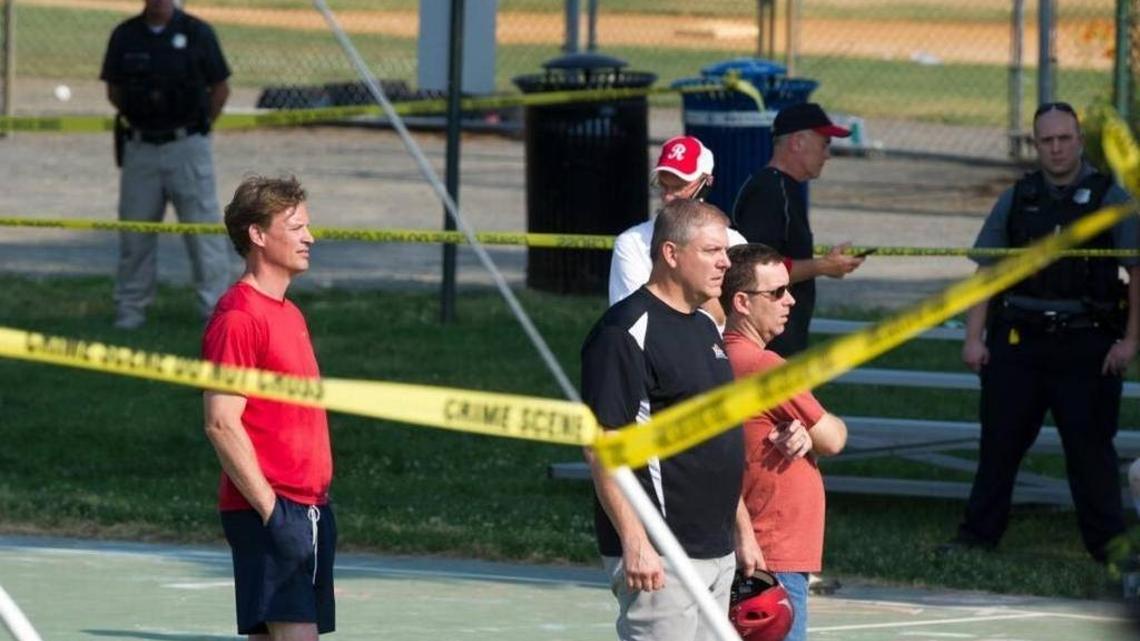 Members of the Republican Congressional baseball team stand behind police tape in Alexandria, Va., June 14 after a gunman wounded House Majority Whip Steve Scalise of Louisiana and four others during a team practice. Police killed the gunman.
