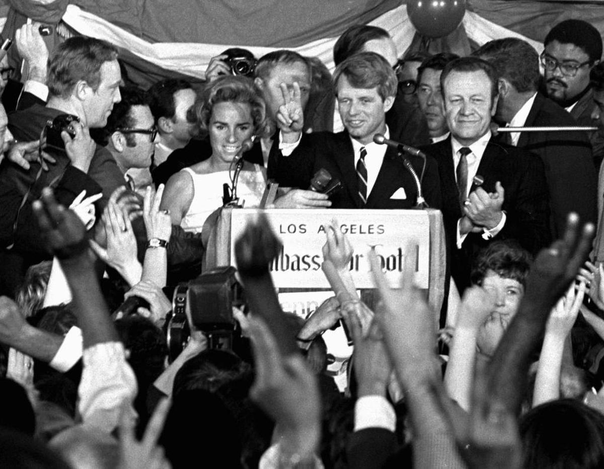 This June 5, 1968 photo shows Sen. Robert F. Kennedy speaking his final words to supporters at the Ambassador Hotel in Los Angeles, moments before he was shot. At his side are his wife, Ethel, left, and his California campaign manager, Jesse Unruh, right. Football player Roosevelt Grier is at right rear.