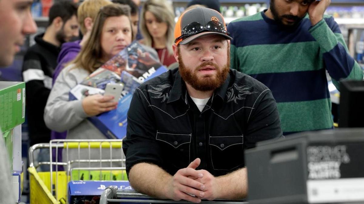 People lined up to check out as they shop a Black Friday sale at a Best Buy store in Overland Park, Kan.