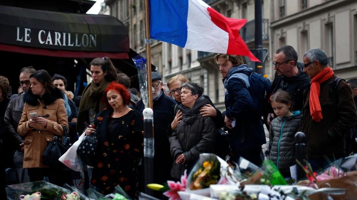 People gathered in front of Le Carillon cafe, a site of the recent attacks, in Paris Monday. French President Francois Hollande says the Paris attacks targeted "youth in all its diversity" and that the victims were of 19 different nationalities.
