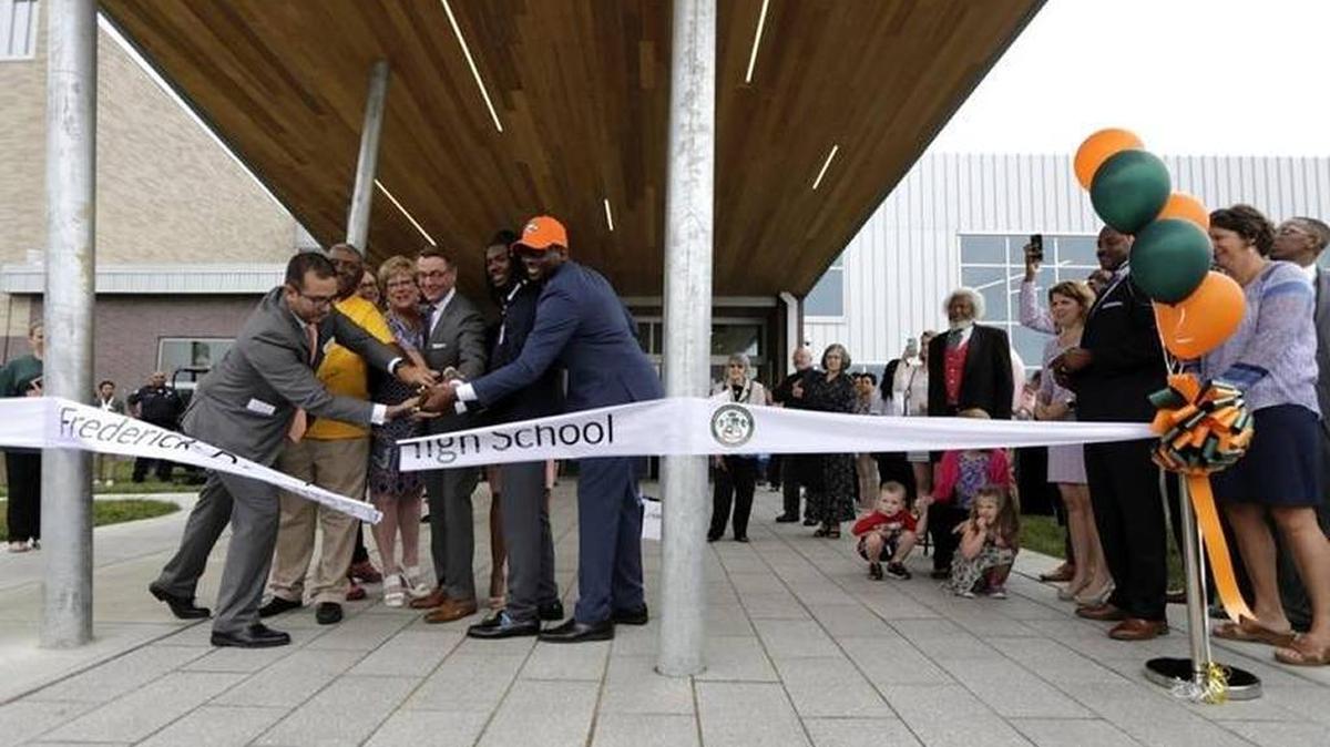Principal Lester Diaz, aided by Mayor Jim Gray and others, cut the ribbon this month, opening the new Frederick Douglass High School in Lexington.