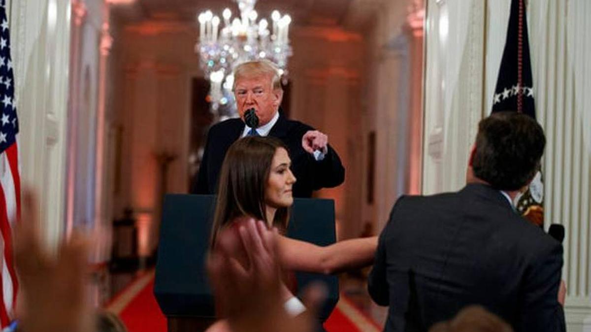 President Donald Trump looked on as a White House intern reached for the microphone held by CNN correspondent Jim Acosta.
