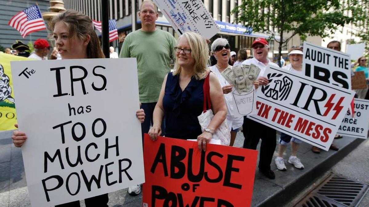 FILE - In this May 21, 2013, file photo, tea party activists demonstrate on Fountain Square before marching to the John Weld Peck Federal Building in Cincinnati to protest the Internal Revenue Service’s targeting of conservative groups seeking tax-exempt status. Tea party activists are heartened by a federal appeals court ruling that strengthens their legal push against the Internal Revenue Service for alleged targeting in past election cycles. A Cincinnati-based panel chastised government foot-dragging while ordering the agency to give attorneys for tea party groups details on tax-exempt applicants. (AP Photo/Al Behrman, File)