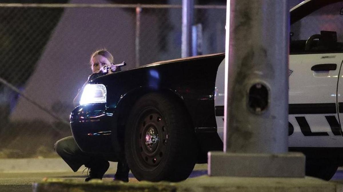 A police officer took cover behind a police vehicle as a sniper rained down rapid fire on a music festival on the Las Vegas Strip Oct 1.