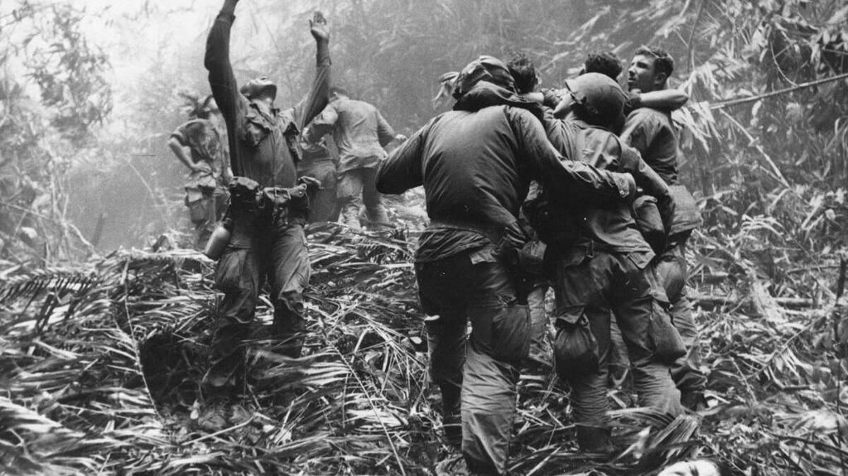 As fellow troopers aided wounded buddies, a paratrooper of A Company, 101st Airborne, guided a medical evacuation helicopter through the jungle foliage to pick up casualties during a five-day patrol of Hue, South Vietnam, in April, 1968.