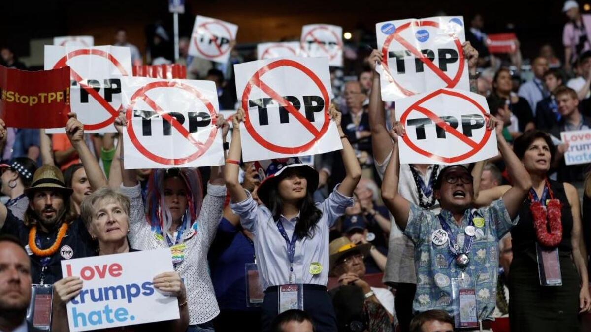 Democratic National Convention delegates held up signs last month against the Trans-Pacific Partnership trade agreement.