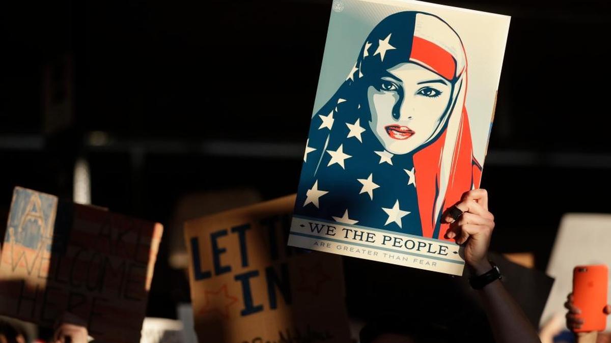 A protester held a sign at San Francisco International Airport during a Saturday demonstration to denounce President Donald Trump's executive order that bars citizens of seven predominantly Muslim-majority countries from entering the U.S.