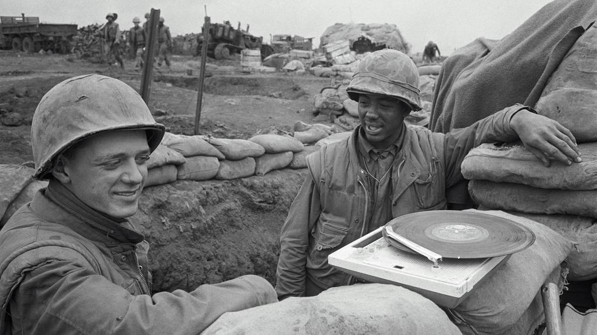 American soldiers listened to a record player as they stood in a trench at the beleaguered U.S. Marine outpost in Khe Sanh, South Vietnam.