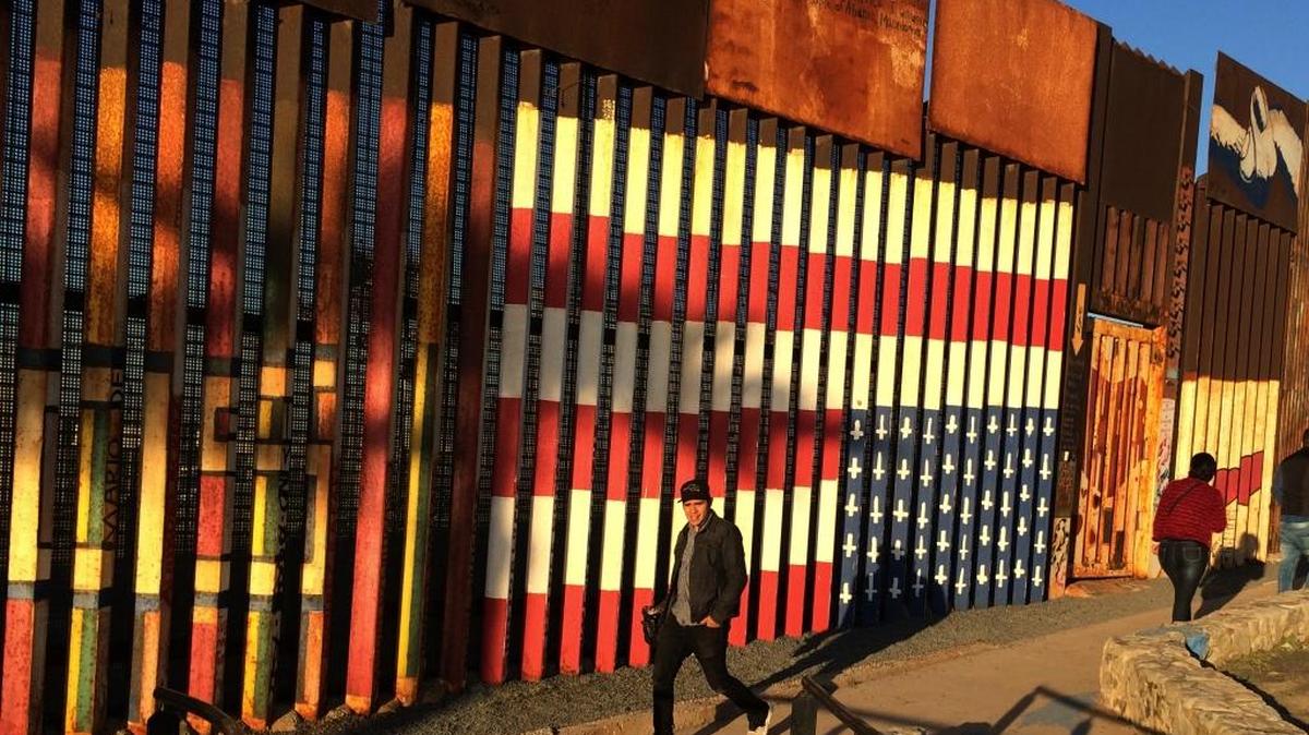 People passed graffiti along the border structure in Tijuana, Mexico last month.