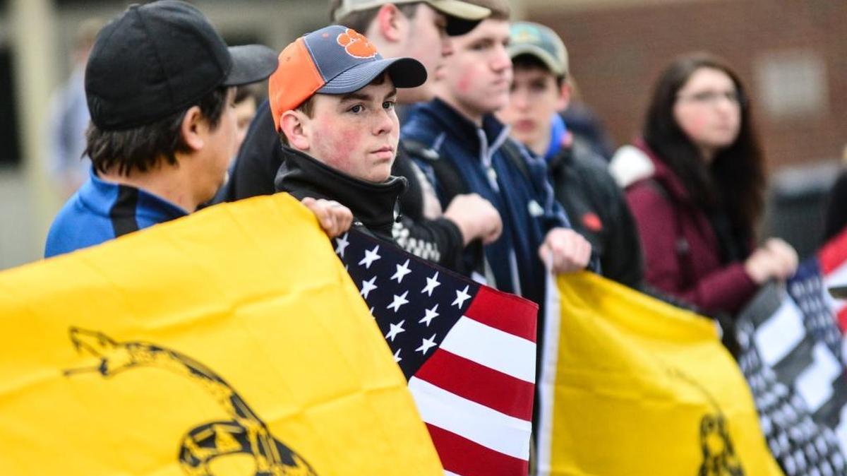 More than two dozen students and citizens gather outside Brattleboro Union High School in Brattleboro, Vt., on March 30, before the start of classes to hold a rally in support of the Second Amendment and gun rights. State lawmakers passed laws to implement universal background checks for all firearms purchases, raise the minimum gun purchase age to 21 years old, and ban the sale of bump stocks and high-capacity ammunition magazines.