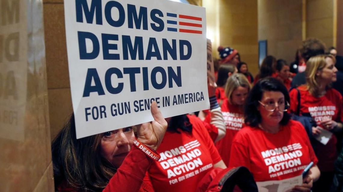 Connie Ortberg, left, holds her sign as women rally at the Minnesota State Capitol on Tuesday as Moms Demand Action called on lawmakers to expand background checks and resist efforts to widen the state’sgun laws after the school shooting in Florida last week.