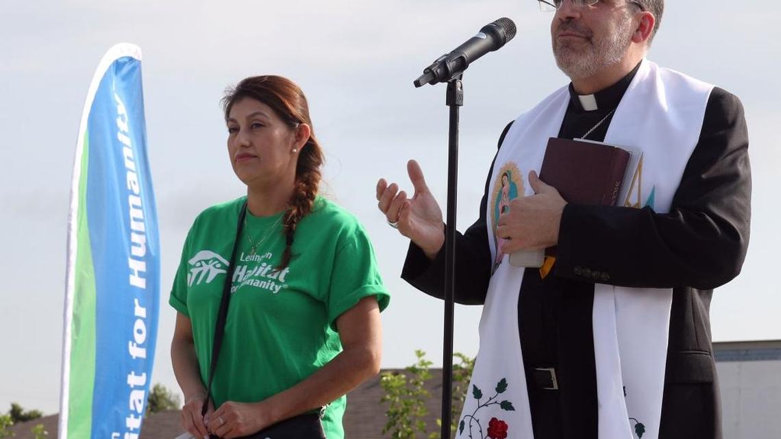 Bishop John Stowe spoke at the blessing of a Habitat for Humanity home for the family of Maria Robles, left, in Lexington in August.
