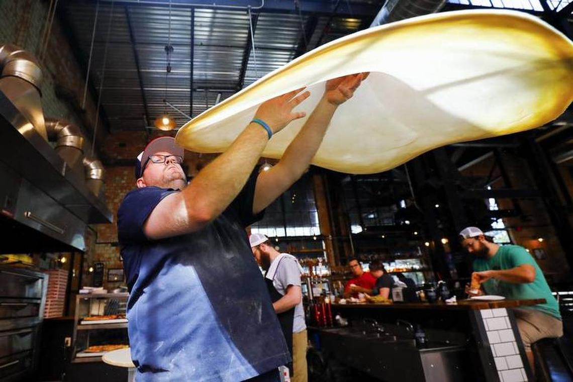 Goodfellas Pizzeria general manager Sean Lindsey tossed pizza dough at Goodfellas in the Distillery District in Lexington.