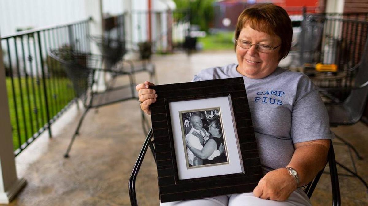 Lisa Hobbs holds a picture of her husband, Gene “Pius” Hobbs, who was killed while working on a Meade County public works crew.