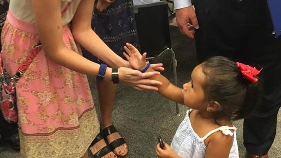 Caroline Smith, the 10-year-old daughter of Sergeant Michael Smith, left, gave Lyncoln Zamarripa, the two-year-old daughter of Officer Patrick Zamarripa, right, a bracelet she made as a memorial for their late fathers and the three other Dallas officers killed during the police shootings there.