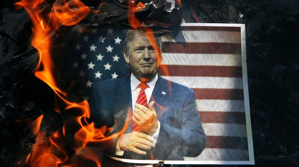 A photo of President Donald Trump is set on fire Sept. 27 by Iranian mourners during the state funeral of a young Revolutionary Guard soldier beheaded by the Islamic State group in Syria. Iran has suffered casualties while its troops are deployed into Iraq fighting the Islamic State group and in Syria.