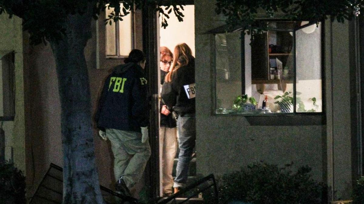 FBI agents search outside a home in connection to the shootings in San Bernardino, Thursday, Dec. 3, 2015, in Redlands, Calif.. A heavily armed man and woman opened fire Wednesday on a holiday banquet, killing multiple people and seriously wounding others in a precision assault, authorities said. Hours later, they died in a shootout with police.