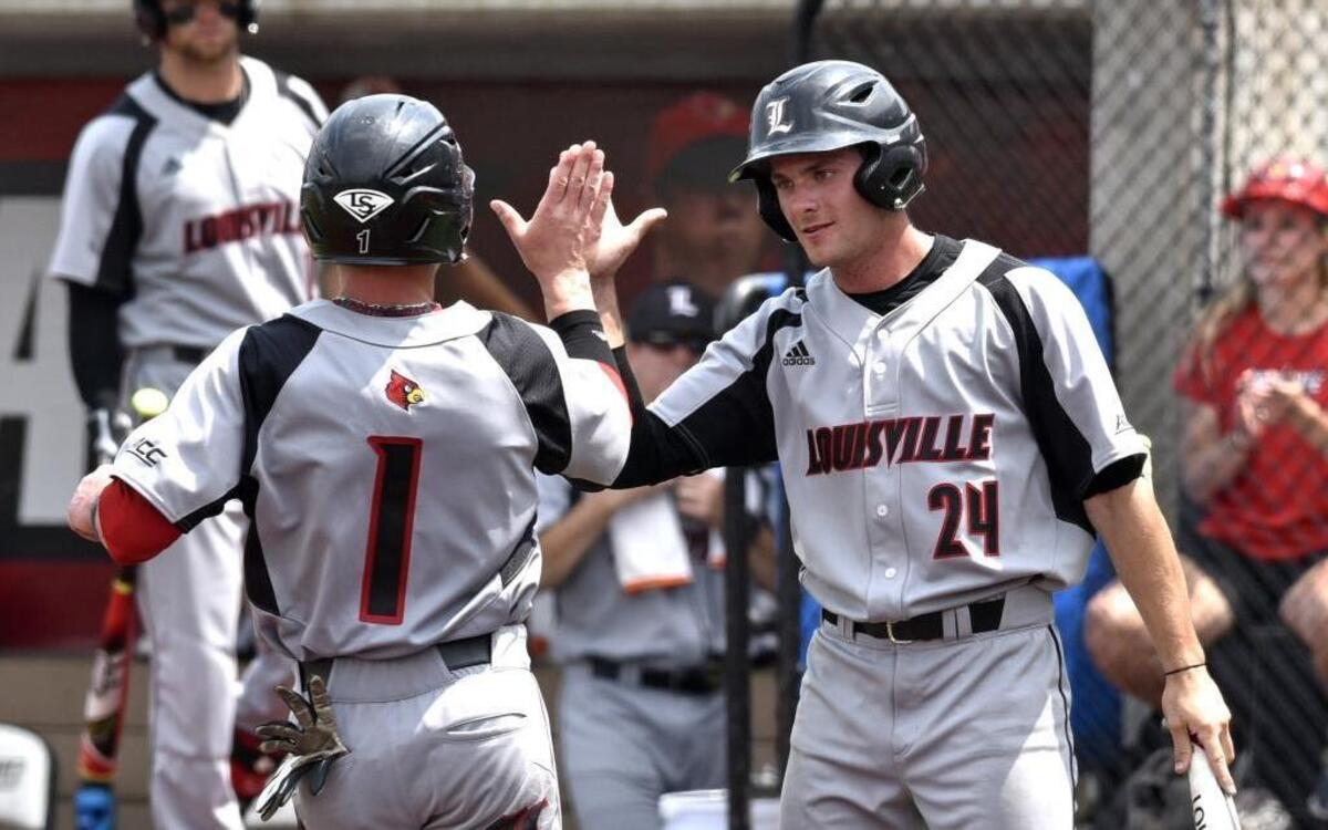Louisville's Sutton Whiting, left, was congratulated by teammate Logan Taylor after scoring during the eighth inning in the Louisville super regional of the NCAA college baseball tournament against Cal State Fullerton on June 7, 2015.