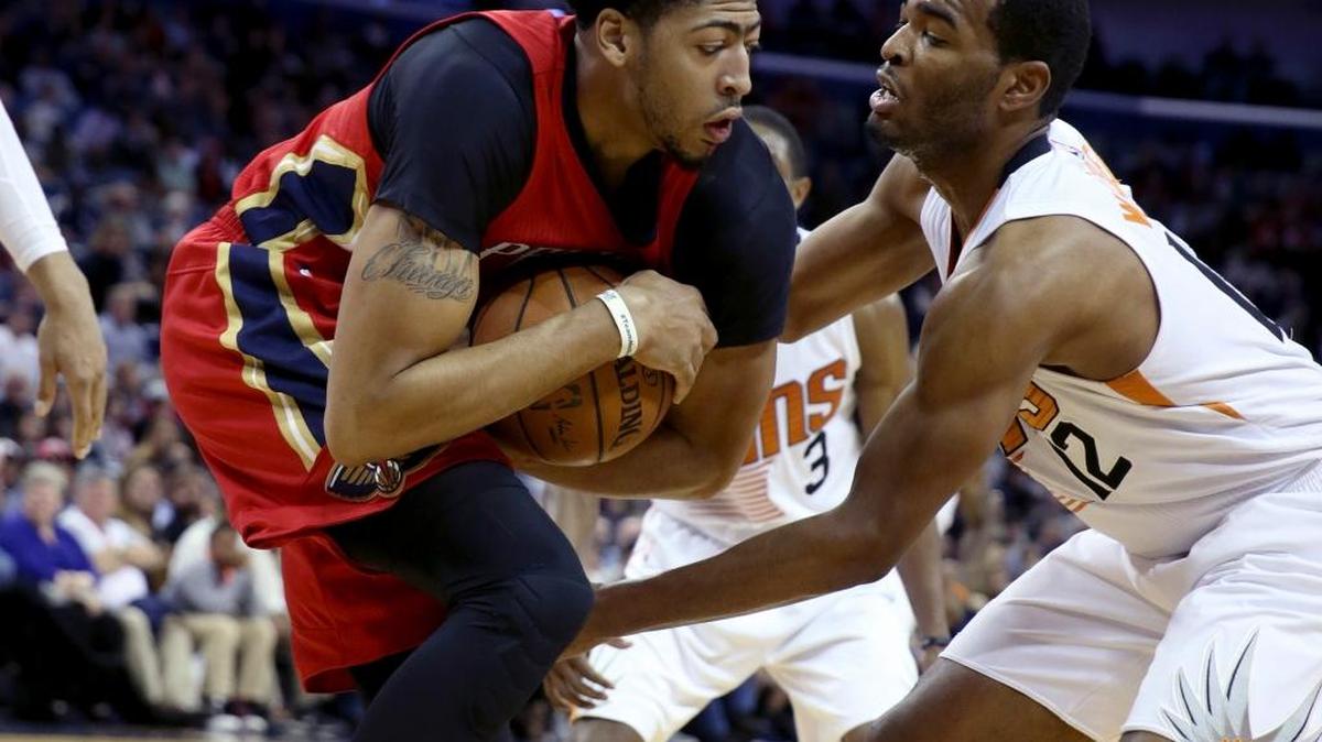 Pelicans forward Anthony Davis, left, kept a rebound away from Suns forward T.J. Warren in the first half.