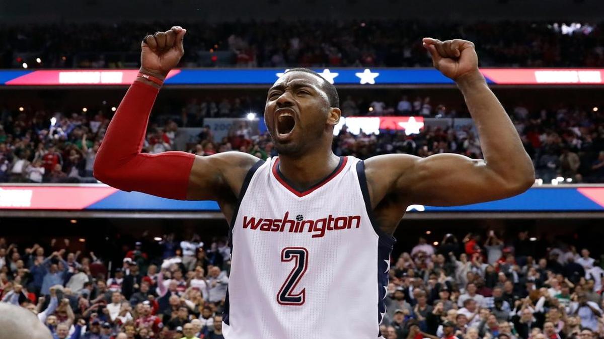 Washington Wizards guard John Wall celebrates as he stands on the scorer's table after Game 6 against the Boston Celtics in an NBA basketball second-round playoff series, Friday, May 12, 2017, in Washington. Wall sank the game-winning 3-point shot. The Wizards won 92-91.
