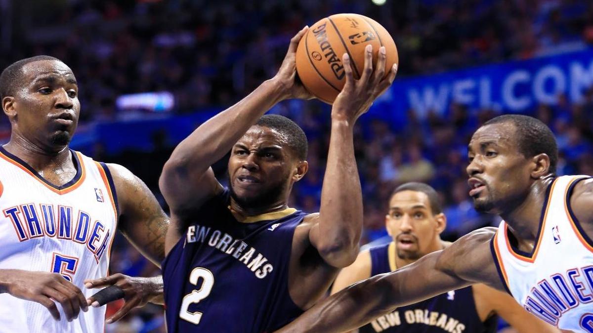 New Orleans Pelicans forward Darius Miller, center, drives to the basket between Oklahoma City Thunder center Kendrick Perkins, left, and Serge Ibaka, right, during the third quarter in Oklahoma City on Friday, April 11, 2014.