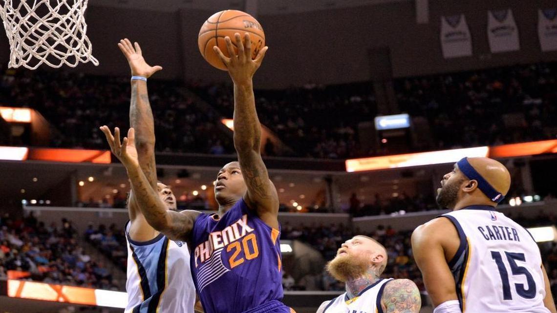 Phoenix Suns guard Archie Goodwin (20) shoots between Memphis Grizzlies guard Mario Chalmers, from left, forward Chris Andersen, and guard Vince Carter (15) in the first half of an NBA basketball game Sunday, March 6, 2016, in Memphis.