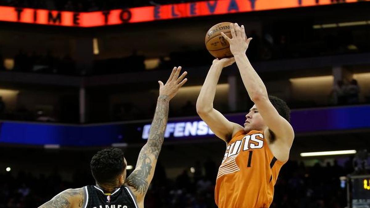 Phoenix Suns guard Devin Booker, right, scores the game-winning basket at the buzzer over Sacramento Kings forward Matt Barnes in the Suns' 105-103 win in an NBA basketball game Friday, Feb. 3, 2017, in Sacramento, Calif.