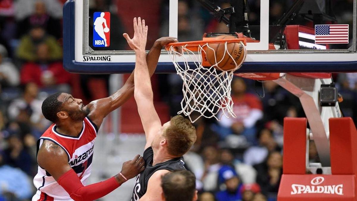 Washington Wizards guard John Wall, left, dunks over Brooklyn Nets center Justin Hamilton, right, during the second half of an NBA basketball game, Friday, Dec. 30, 2016, in Washington. The Wizards won 118-95.
