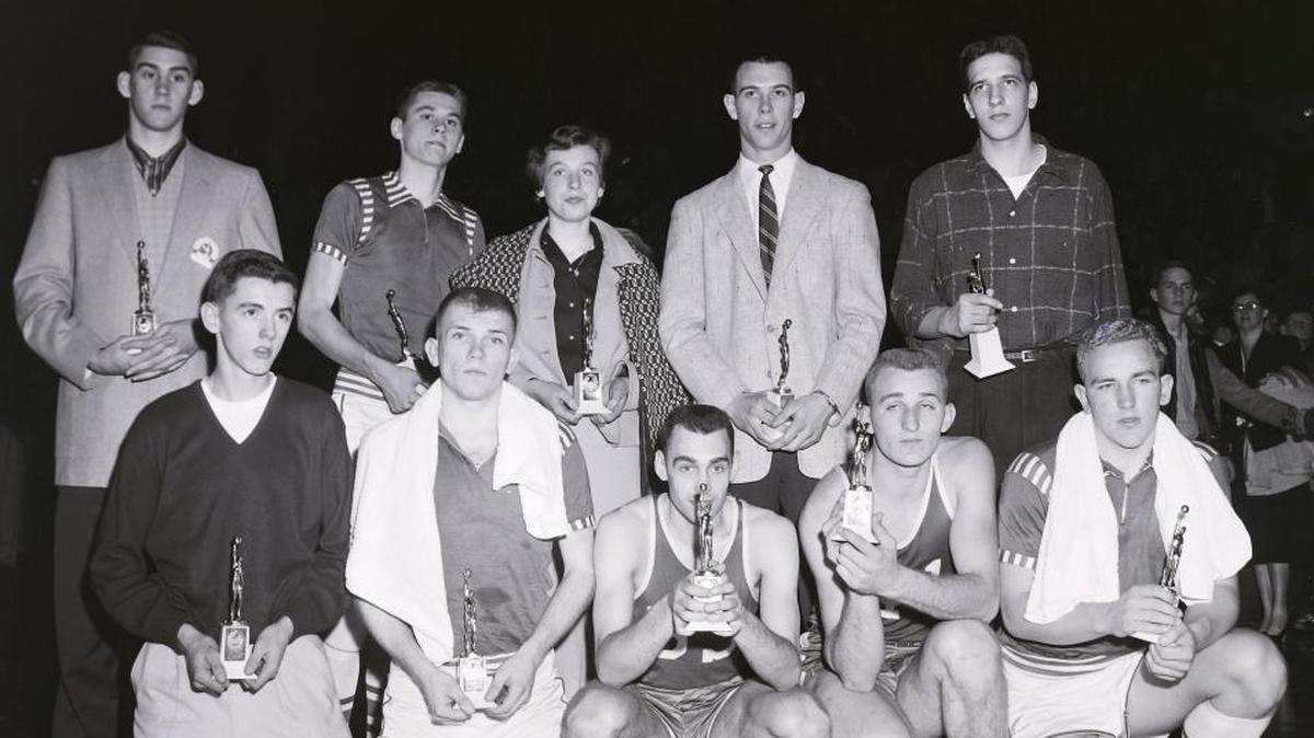 The 1956 All-State High School Basketball Tournament Team, plus the sister of Kelly Coleman, who accepted the gift in King Kelly’s absence. Front row, left to right, Rex Story, Mayfield; Dave Eakins, Henderson; E.A. Couch, Carr Creek; Bobby Shepherd, Carr Creek; Pascal Benson, Henderson; back row, Harry Todd, Earlington; Byron Pinson, Henderson; Linda Coleman, Wayland; Corky Withrow, Central City, and Billy Ray Lickert, Lafayette. Photo was taken after Carr Creek defeated Henderson 72-68 for the state title on March 17, 1956, in Memorial Coliseum.