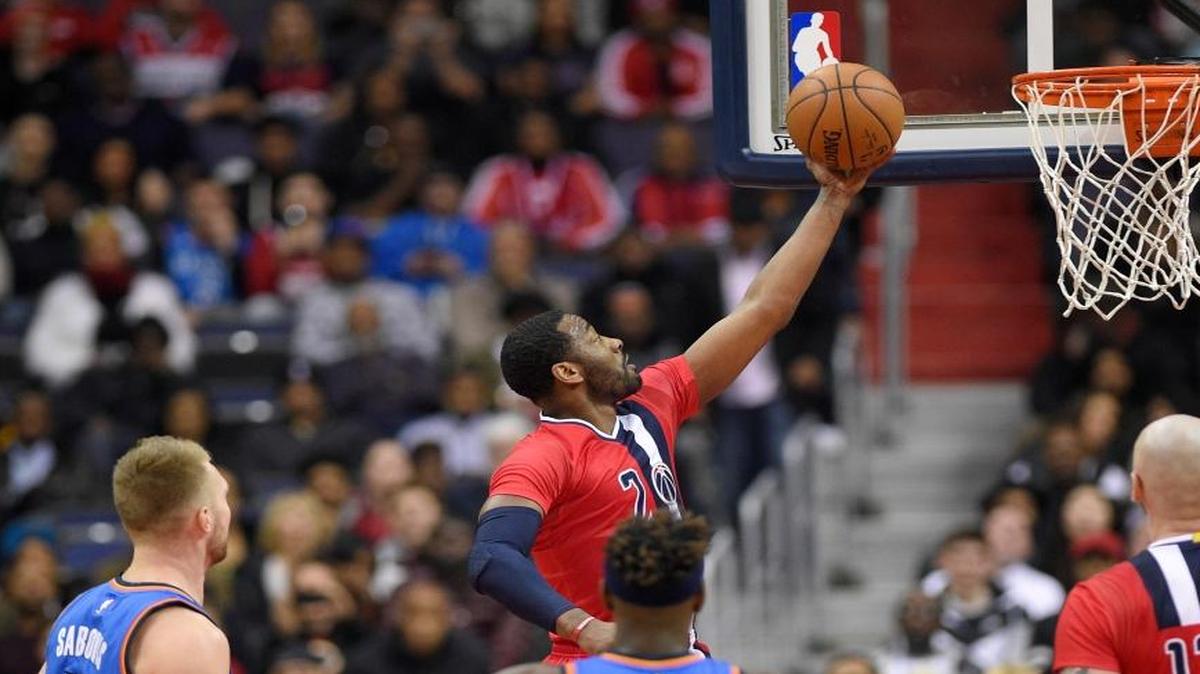 Washington Wizards guard John Wall (2) goes to the basket against Oklahoma City Thunder forward Domantas Sabonis (3) and guard Anthony Morrow (2) during the first half of an NBA basketball game, Monday, Feb. 13, 2017, in Washington. Also seen is Washington Wizards center Marcin Gortat (13).
