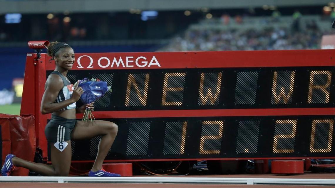 Kendra Harrison of the US poses next to the time she ran to win the women's 100 meter hurdles in a world record time of 12.20 seconds during the Diamond League anniversary games at The Stadium, in the Queen Elizabeth Olympic Park in London, Friday, July 22, 2016.