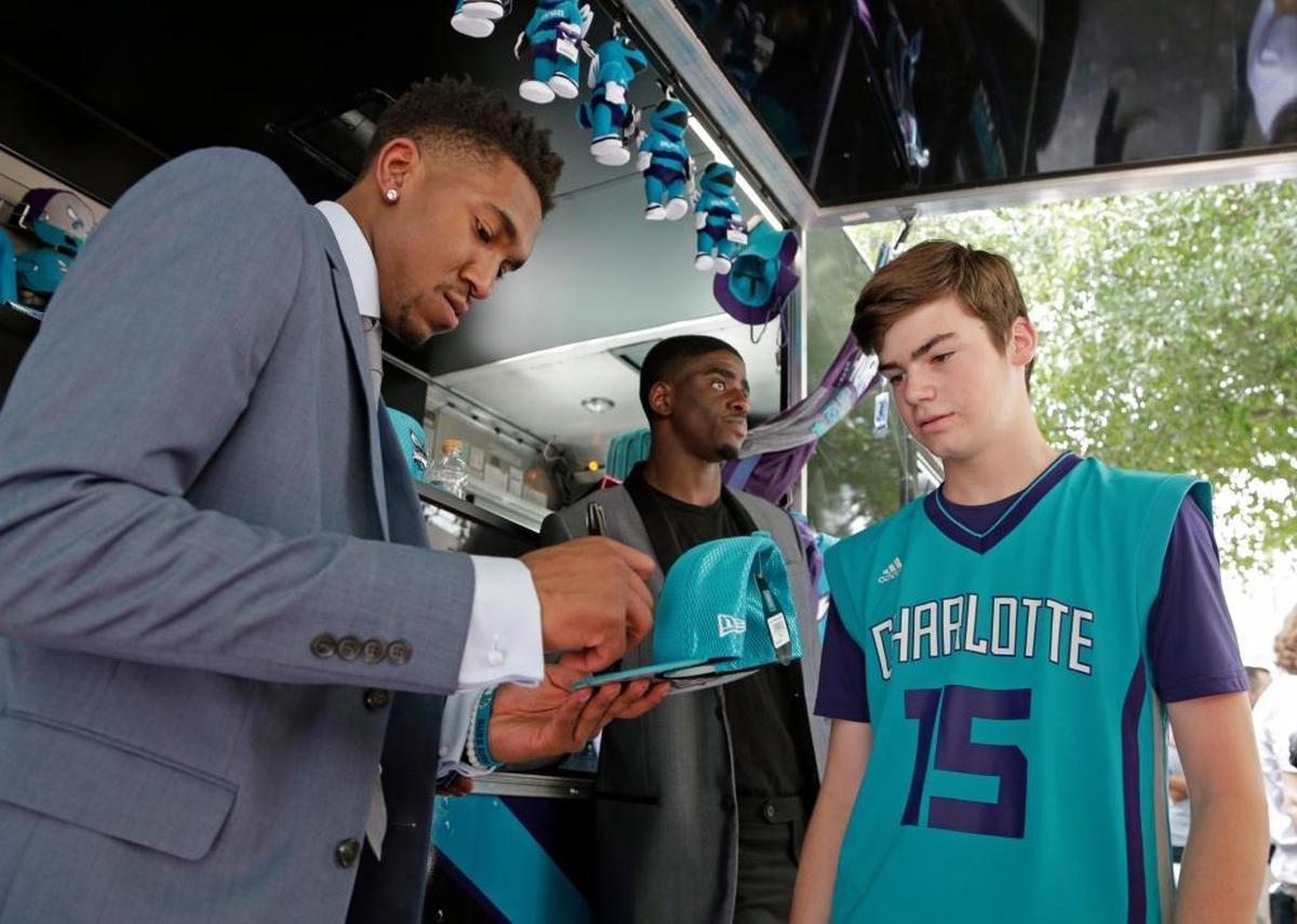 Charlotte Hornets NBA basketball draft pick Malik Monk, left, signs an autograph for a fan in Charlotte, N.C., Friday, June 23, 2017. Another Hornets draft pick, Dwayne Bacon, is at rear.