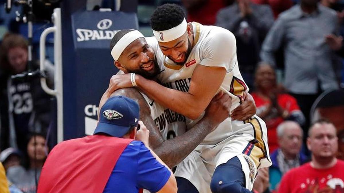 New Orleans Pelicans forward Anthony Davis jumps on center DeMarcus Cousins after overtime of an NBA basketball game against the Chicago Bulls in New Orleans, Monday, Jan. 22, 2018. The Pelicans won in double overtime, 132-128.