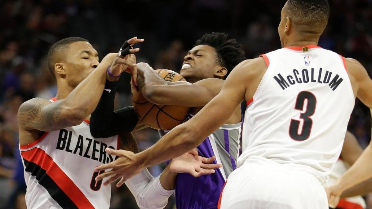 Portland Trail Blazers guard Damian Lillard, left, forces a jump ball with Sacramento Kings guard De'Aaron Fox during the first quarter of an NBA basketball game Friday, Nov. 17, 2017, in Sacramento, Calif. (AP Photo/Rich Pedroncelli)