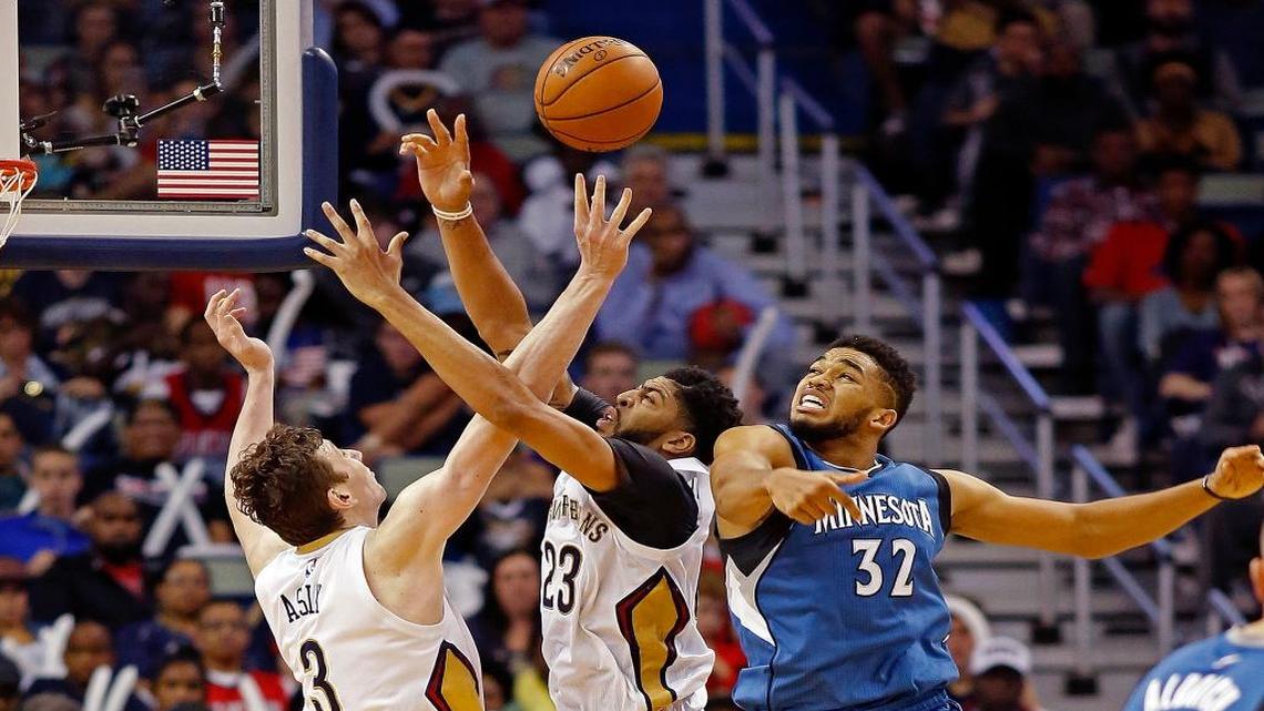 New Orleans Pelicans center Omer Asik, left, and forward Anthony Davis, center, and Minnesota Timberwolves center Karl-Anthony Towns, right, reach for a rebound during the second half of an NBA basketball game in New Orleans, Wednesday, Nov. 23, 2016. The Pelicans won 117-96.