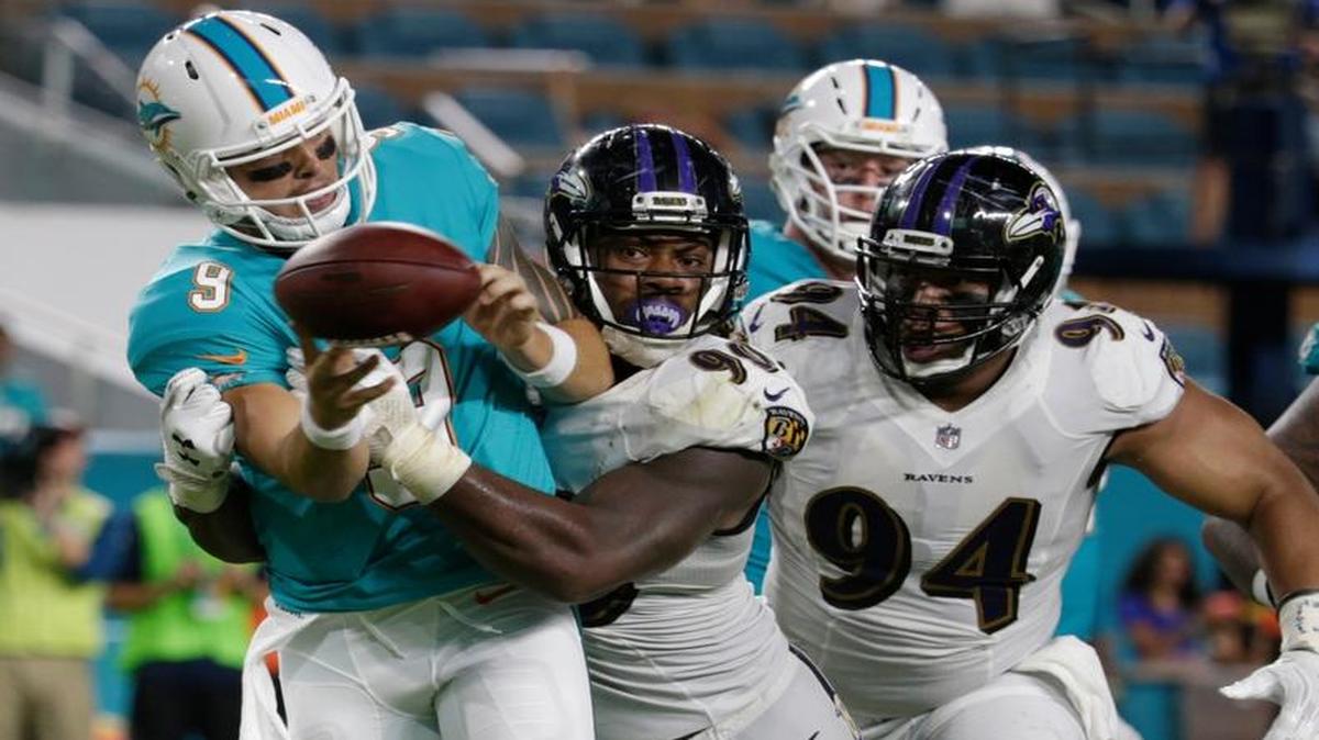 Baltimore Ravens outside linebacker Za’Darius Smith (90) and defensive end Carl Davis (94), pressure Miami Dolphins quarterback David Fales (9), during the first half of an NFL preseason football game, Thursday, Aug. 17, 2017, in Miami Gardens, Fla.