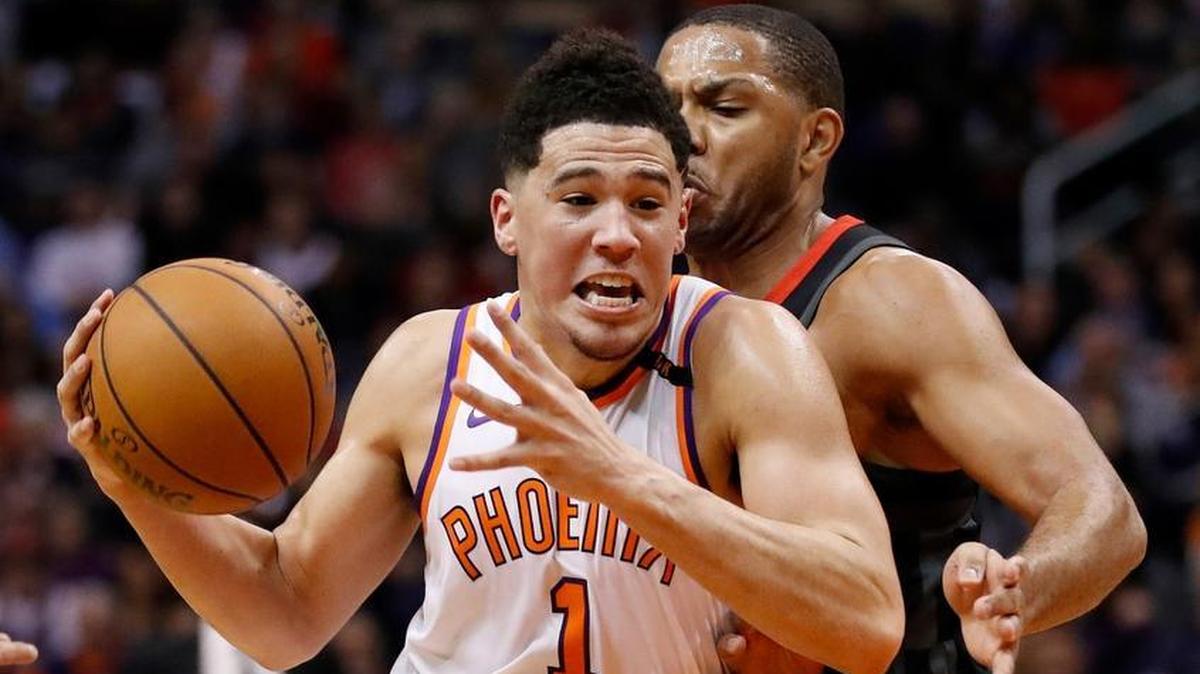 Phoenix Suns guard Devin Booker (1) drives past Houston Rockets guard Eric Gordon during the second half of an NBA basketball game Friday, Jan. 12, 2018, in Phoenix.