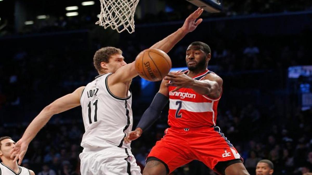 Washington Wizards guard John Wall (2) passes around Brooklyn Nets center Brook Lopez (11) in the first half of an NBA basketball game, Saturday, Dec. 26, 2015, in New York.