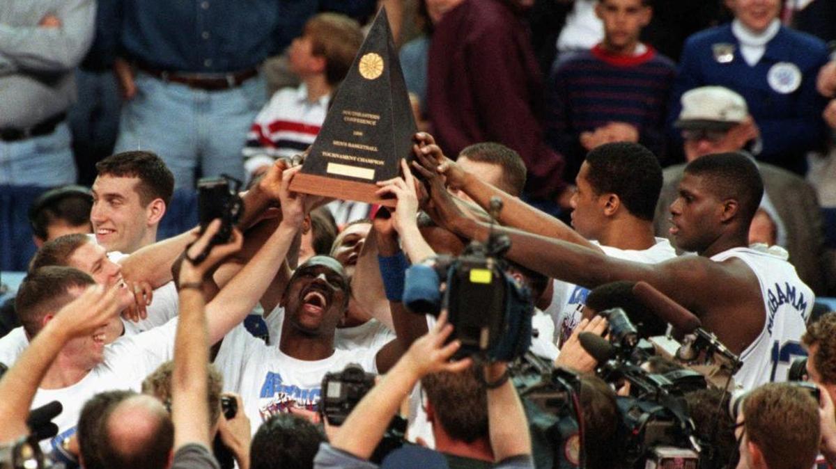 Kentucky’s Allen Edwards (3), surrounded by teammates, held up the SEC Championship trophy after the Cats’ 86-56 defeat of South Carolina in the Georgia Dome in Atlanta on Sunday, March 8, 1998.