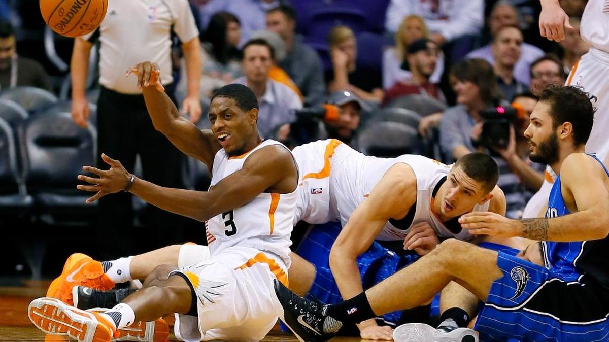 Suns guard Brandon Knight (3) came up with the basketball as teammate Alex Len, rear, and Magic forward Evan Fournier, right, looked on during the second half Wednesday, Dec. 9, 2015, in Phoenix. The Suns won 107-104.