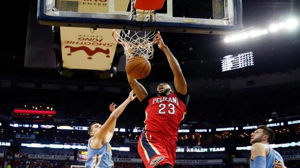 New Orleans Pelicans forward Anthony Davis (23) slam dunks over Denver Nuggets center Nikola Jokic (15) in the first half of an NBA basketball game in New Orleans, Wednesday, Oct. 26, 2016.