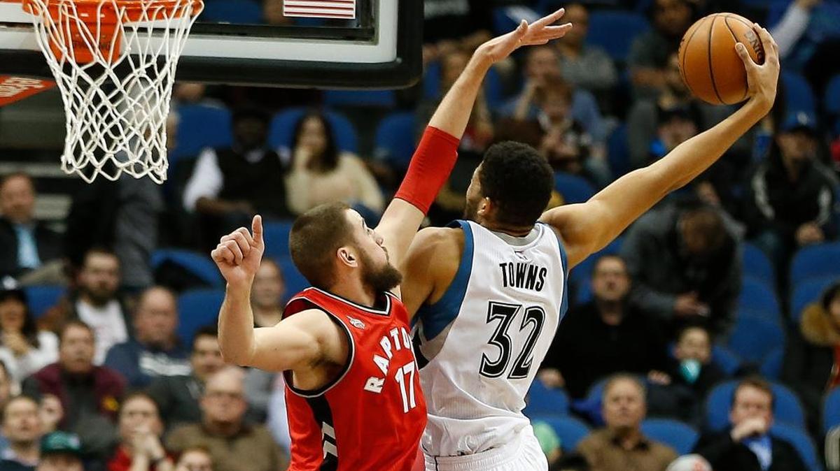 Minnesota Timberwolves center Karl-Anthony Towns (32) stretches out to shoot the ball against Toronto Raptors center Jonas Valanciunas (17) in the second half of an NBA basketball game Wednesday, Feb. 10, 2016, in Minneapolis. The Wolves won 117-112.