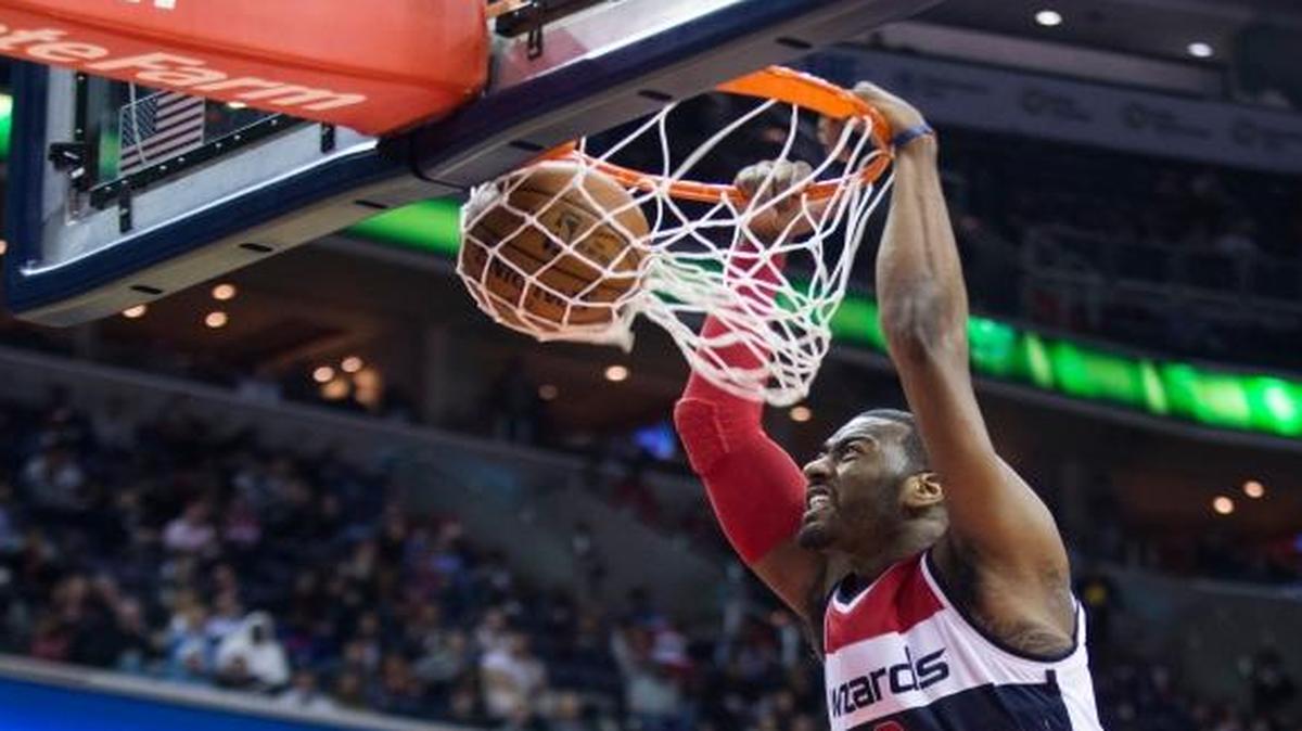 76ers guard Ish Smith, left, and forward Carl Landry, second from left, looked on as Wizards guard John Wall dunked during the second half on Monday, Feb. 29, 2016, in Washington. The Wizards defeated the 76ers 116-108.