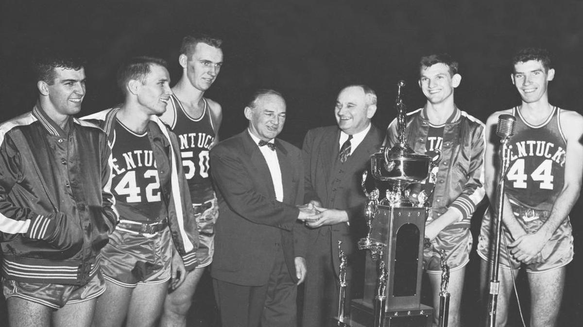 Coach Adolph Rupp and his University of Kentucky starters wore broad smiles on Dec. 23, 1954, as Rupp received congratulations from Ken Loeffler, coach of LaSalle, whose team was a 63-54 victim of the Wildcats in the championship game of the UK Invitational tournament. The players beaming over the big trophy are (from left) Linville Puckett, Bill Evans, Bob Burrow, Jerry Bird and Phil Grawemeyer.