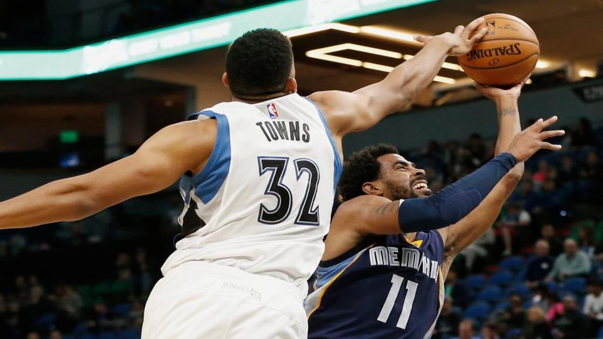Minnesota Timberwolves' Karl-Anthony Towns, left, tries to block a shot by Memphis Grizzlies' Mike Conley during the second half of an NBA preseason basketball game Wednesday, Oct. 19, 2016, in Minneapolis. The Timberwolves won 101-94.
