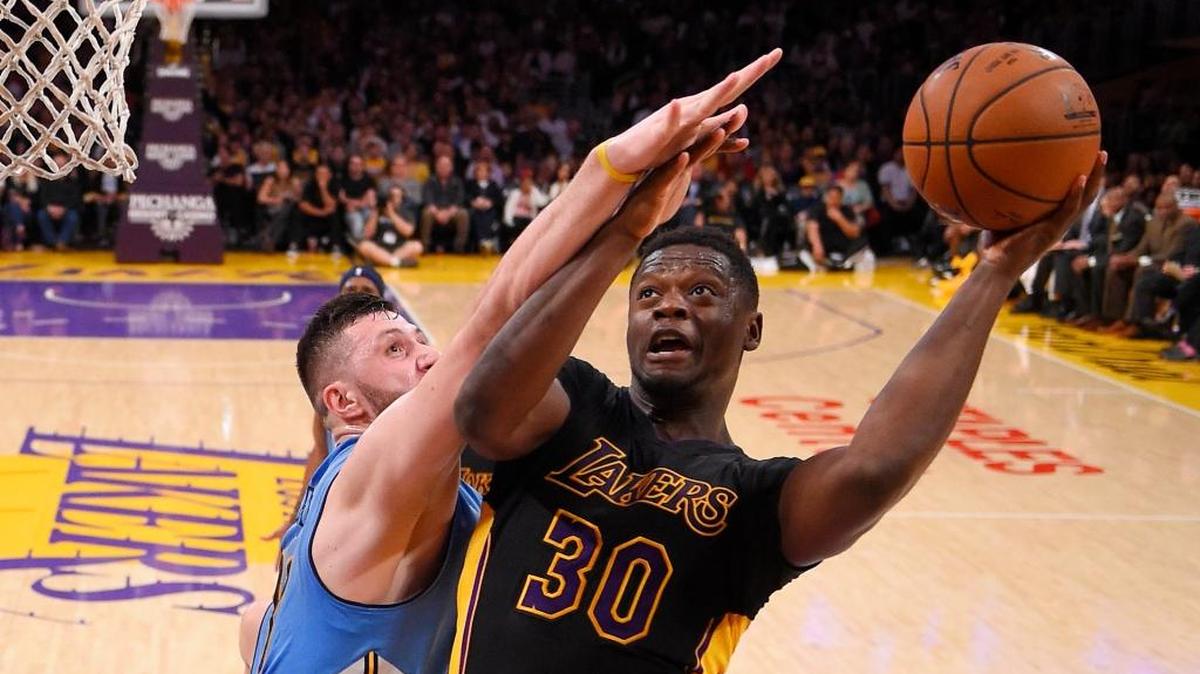 Los Angeles Lakers forward Julius Randle, right, shoots as Denver Nuggets center Jusuf Nurkic, of Bosnia, defends during the second half of an NBA basketball game, Friday, March 25, 2016, in Los Angeles.