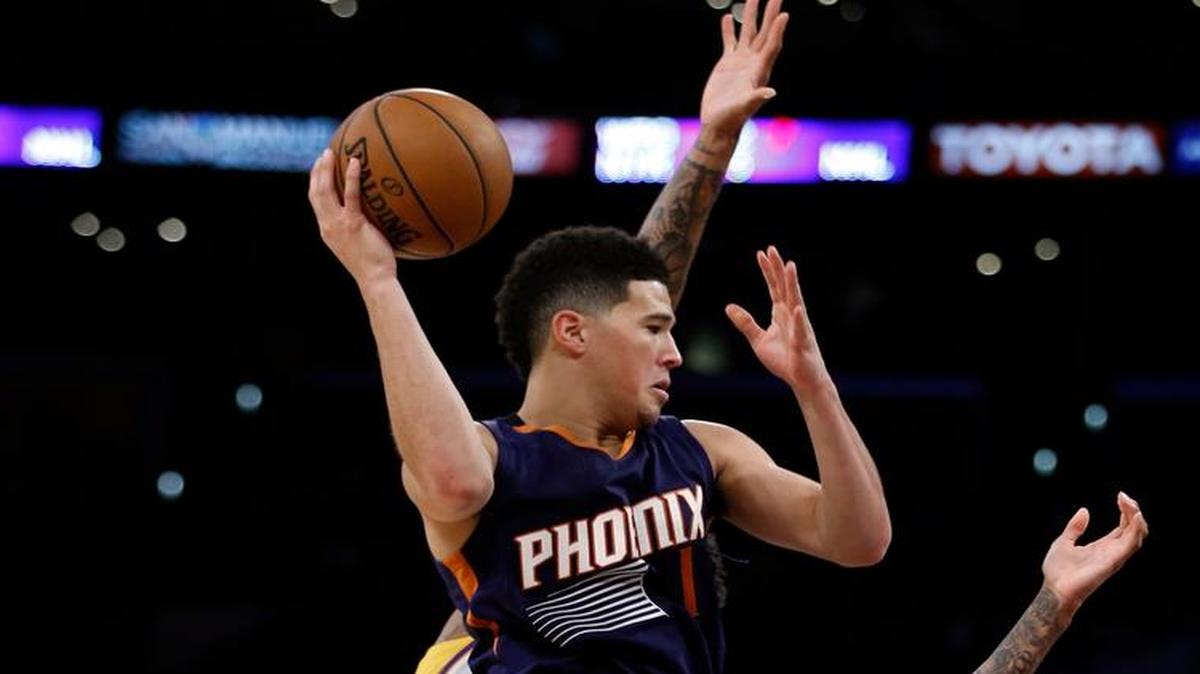 Phoenix Suns guard Devin Booker (1) leaps in the air and looks to pass the ball around against Los Angeles Lakers forward Brandon Ingram (14) during the second half of an NBA basketball game in Los Angeles, Sunday, Nov. 6, 2016. The Lakers won 119-108.