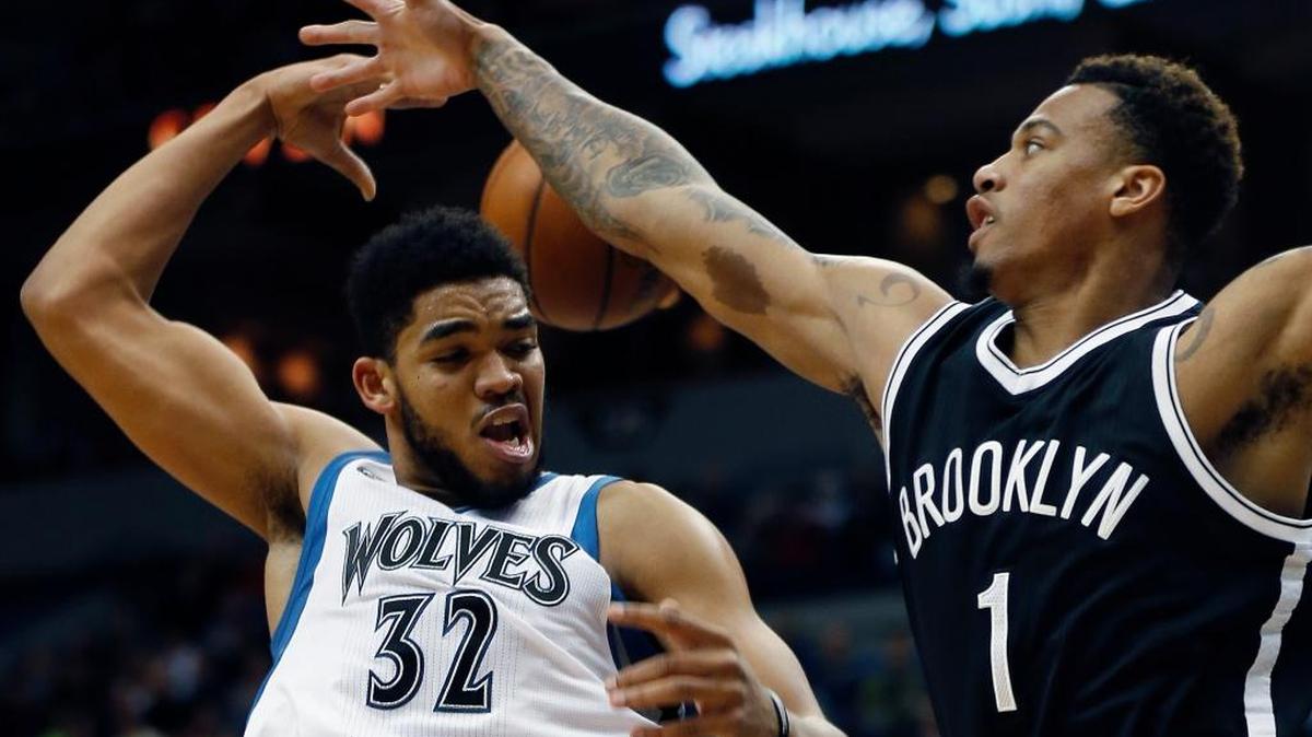 Timberwolves forward Karl-Anthony Towns (32) passes behind himself against the defense of Nets forward Chris McCullough in the second half on Saturday, March 5, 2016, in Minneapolis. The Timberwolves won 132-118.