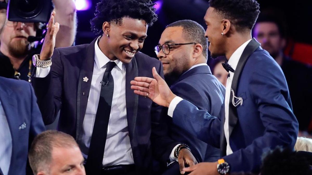 Kentucky's De' Aaron Fox, left, reacts after being selected by the Sacramento Kings as the fifth pick overall during the NBA basketball draft, Thursday, June 22, 2017, in New York.
