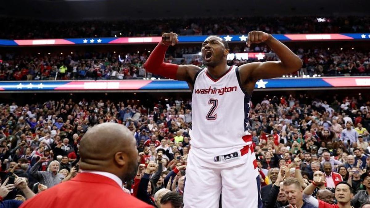 Washington Wizards guard John Wall celebrates as he stands on the scorer's table after Game 6 against the Boston Celtics in an NBA basketball second-round playoff series, Friday, May 12, 2017, in Washington. Wall sank the game-winning 3-point shot. The Wizards won 92-91.